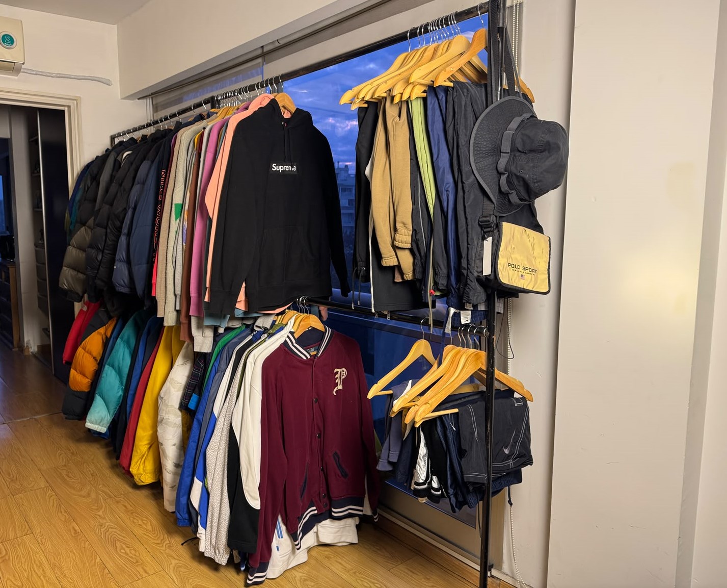 Percheros del showroom Cauzer con camperas, buzos y varsity